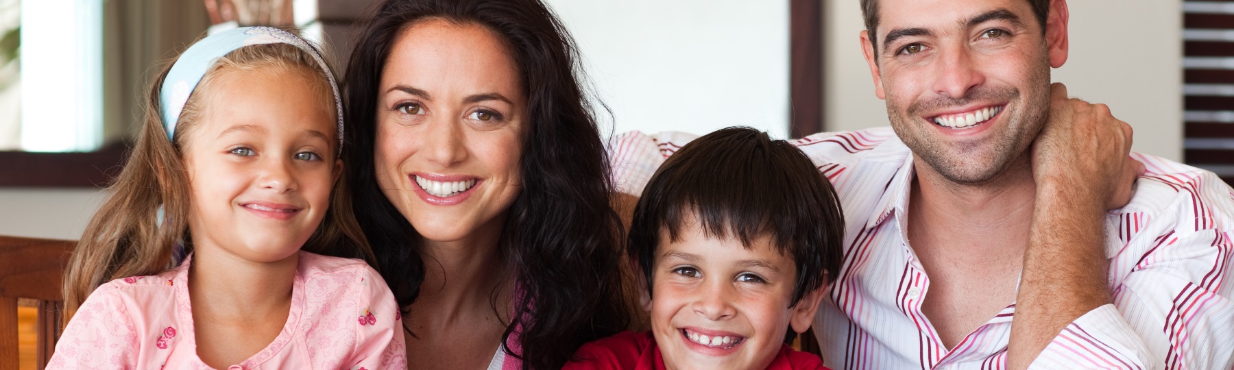 family of four smiling into camera